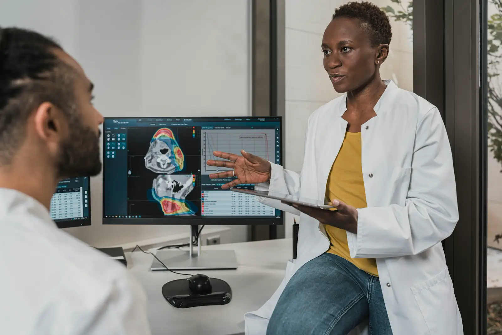 A clothed clinician talking with a patient in an office