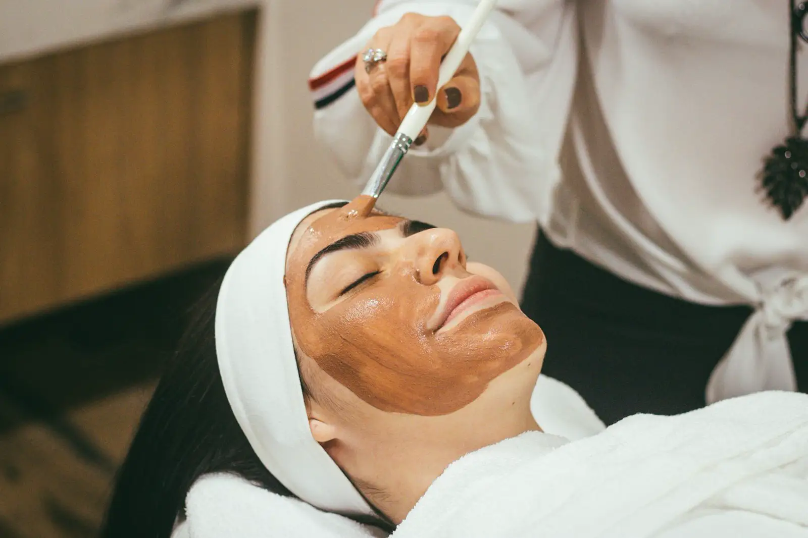 A person receiving a facial skincare treatment, face only